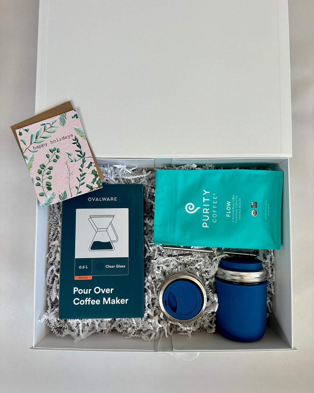 Gift box containing a Pour Over Coffee Maker, Purity Coffee package, and a card with greenery design.