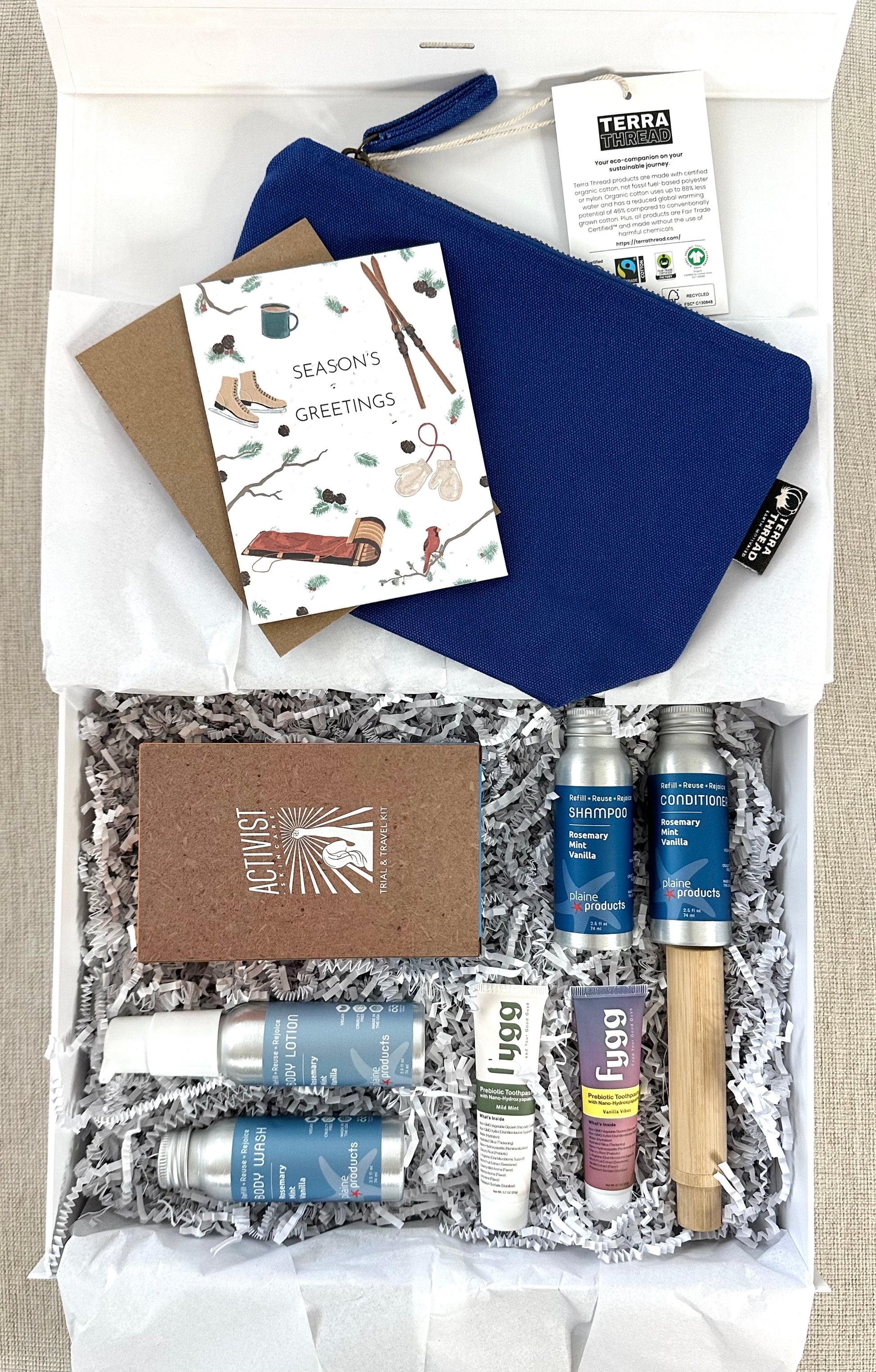 Gift set with blue pouch, cards, and beauty products in a box