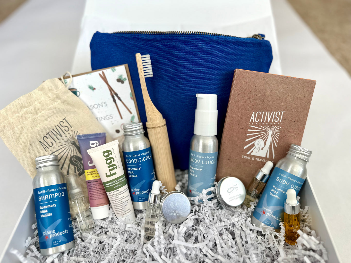 Collection of toiletries including bottles, a toothbrush, and books with 'Activist' branding on a white background.