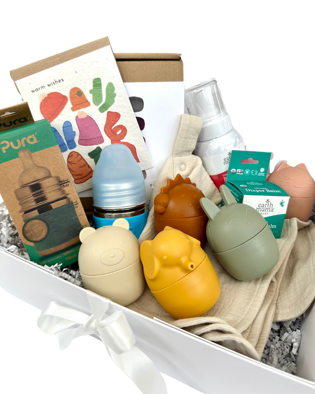 Organic and non-toxic baby gift box that includes assorted baby products including bottles and toys in a box on a white background